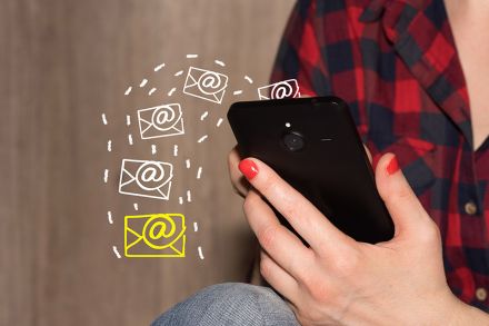 Foto: Frau hält Mobiltelefon in der Hand